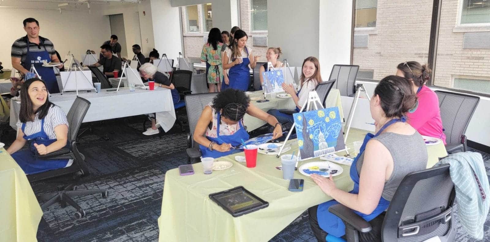 A team building event featuring people sitting at tables in an office.