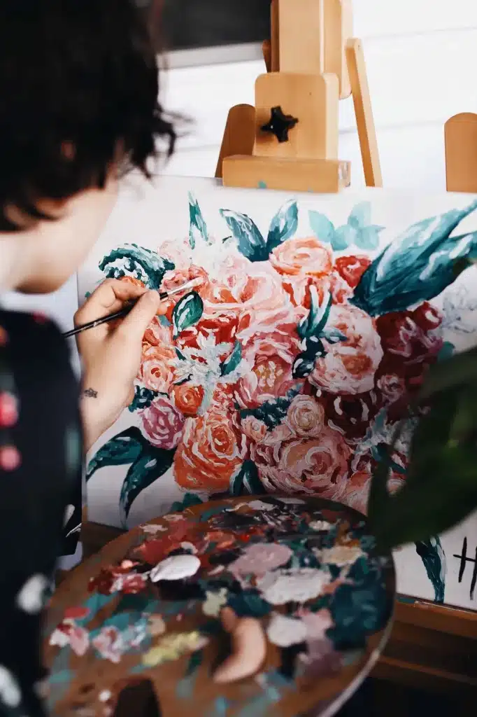 A woman engrossed in painting beautiful flowers on an easel at a sip and paint event in Washington DC.