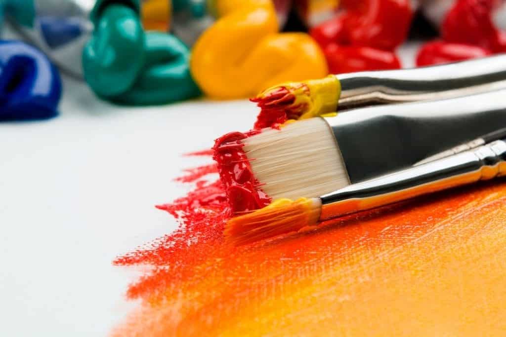 A group of paint brushes on a white surface.