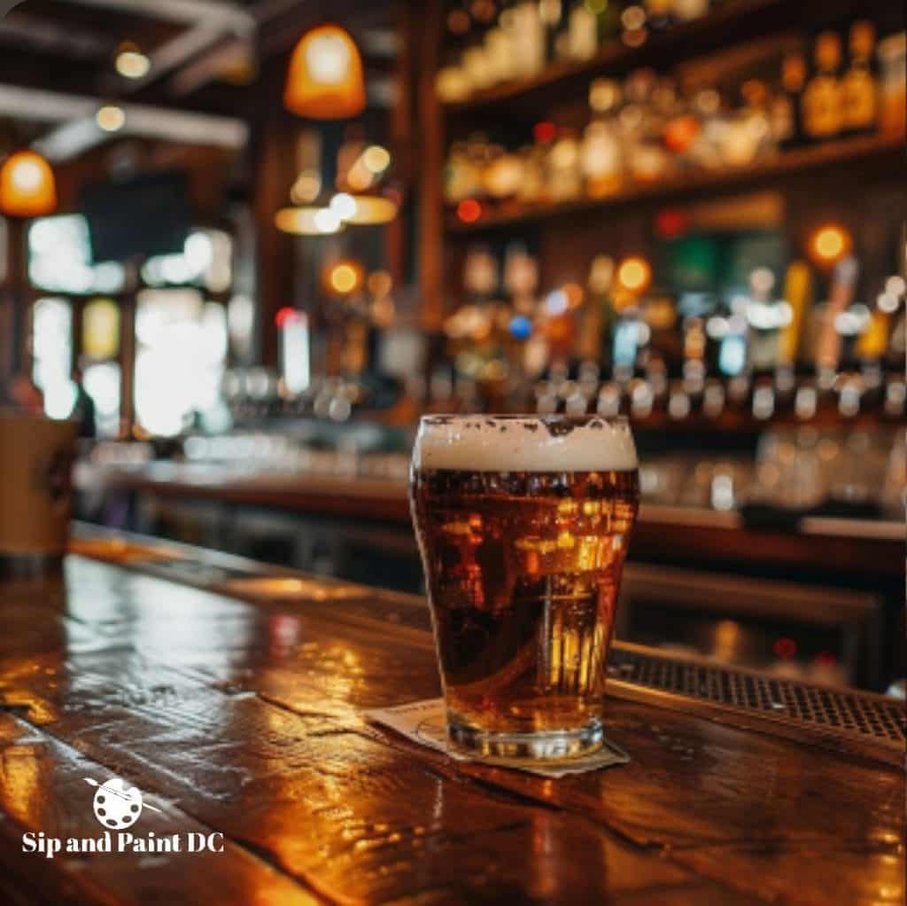 A pint of beer on a bar counter with blurred shelves of liquor bottles in the background.