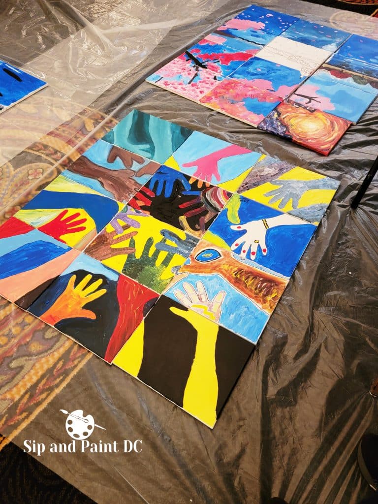 Canvases arranged to depict a monument against a colorful sky and water reflection from a Sip and Paint DC event.
