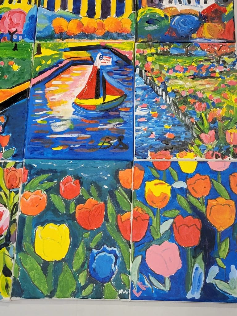 Colorful paintings arranged together depict scenes of tulips, a sailboat on water, and a garden with various flowers in bright, vivid colors.